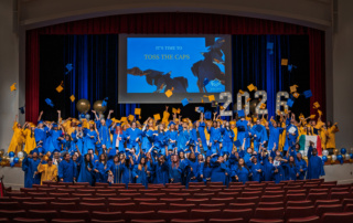 Restore Education 2026 graduates tossing their caps in celebration at commencement