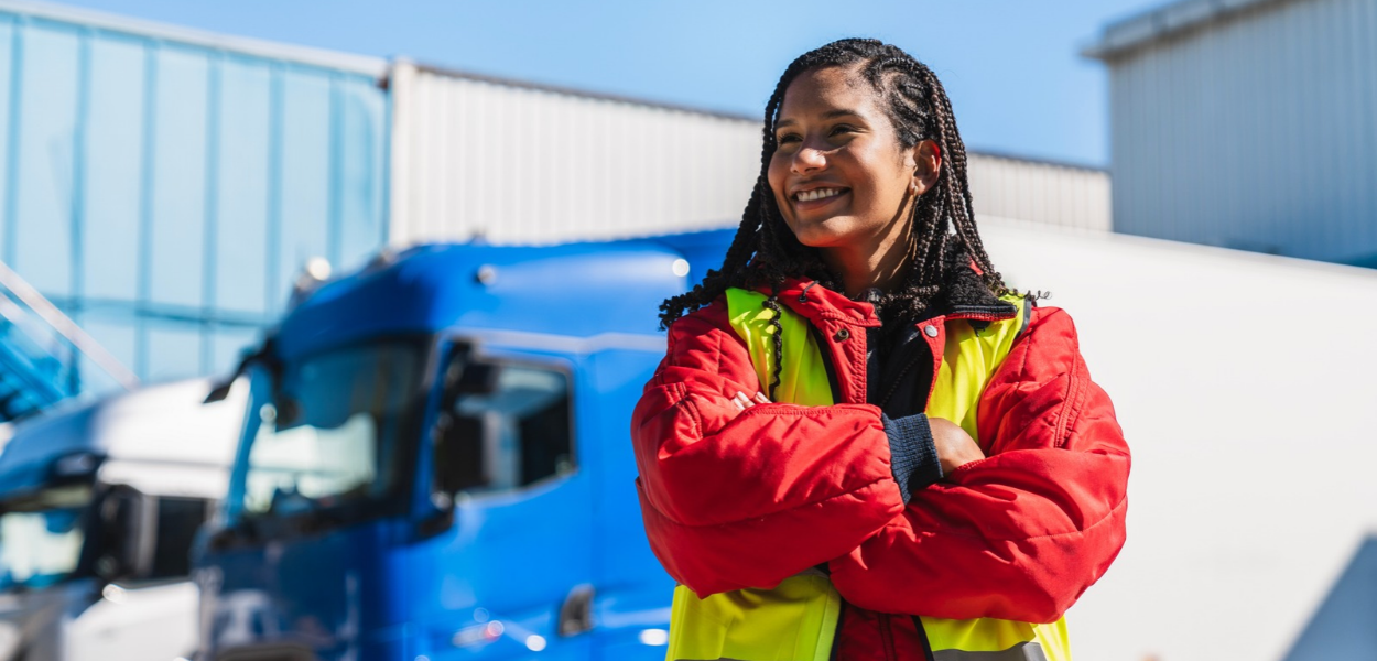 A student in a hi-vis safety vest stands in front of a semi truck as part of Commercial Driver's License (CDL) training in San Antonio.